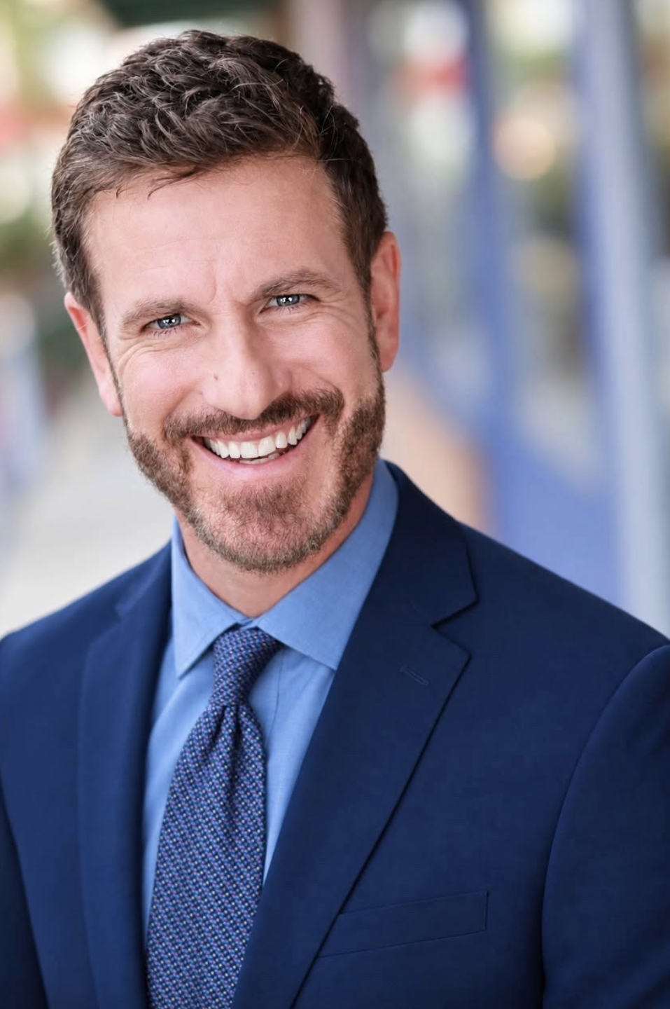 Tyler Haines smiling in a blue suit